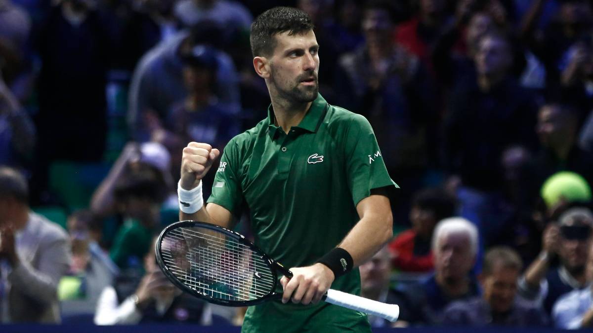Novak Djoković na korcie tenisowym, świętujący z zaciśniętą pięścią.