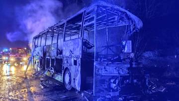 Spalony autobus po wypadku nocą na drodze