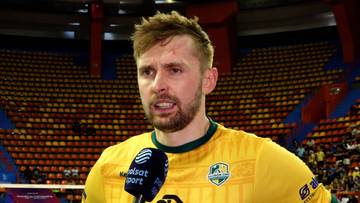 Portret siatkarza Mateusza Bieńka w żółtej koszulce, trzymającego mikrofon.