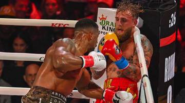 Dw&oacute;ch bokser&oacute;w w ringu podczas walki. Jeden z nich, Joshua, wyprowadza cios.