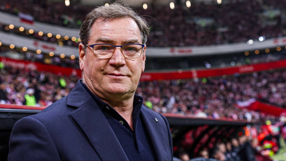 Jan Urban, selekcjoner reprezentacji Polski w piłce nożnej, na tle trybun stadionu.