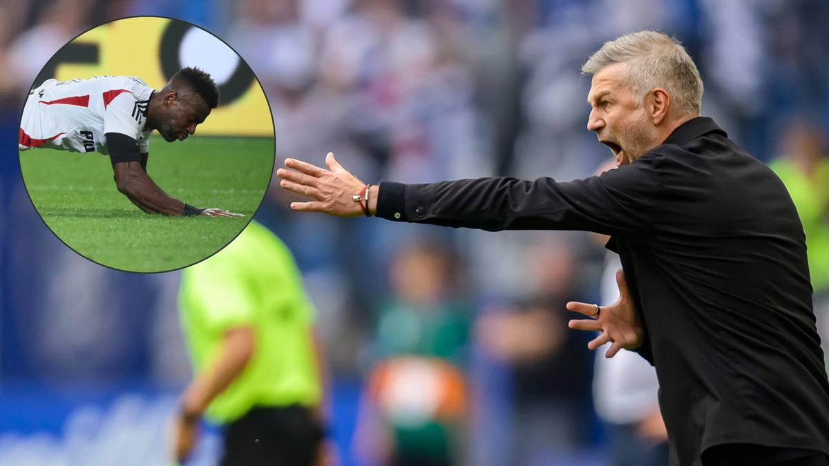 Piłkarz Legii Warszawa, Nsame, leży na murawie boiska bez kontaktu z przeciwnikiem. Obok trener klubu gestykuluje, wyrażając emocje.