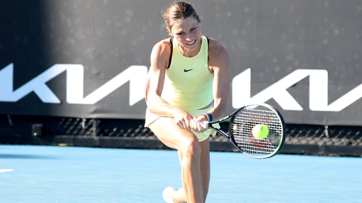 Kobieta grająca w tenisa, uderzająca piłkę rakietą.