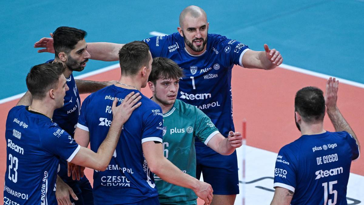 Siatkarze w niebieskich strojach i jeden zawodnik w zielonym trykocie podczas meczu siatk&oacute;wki