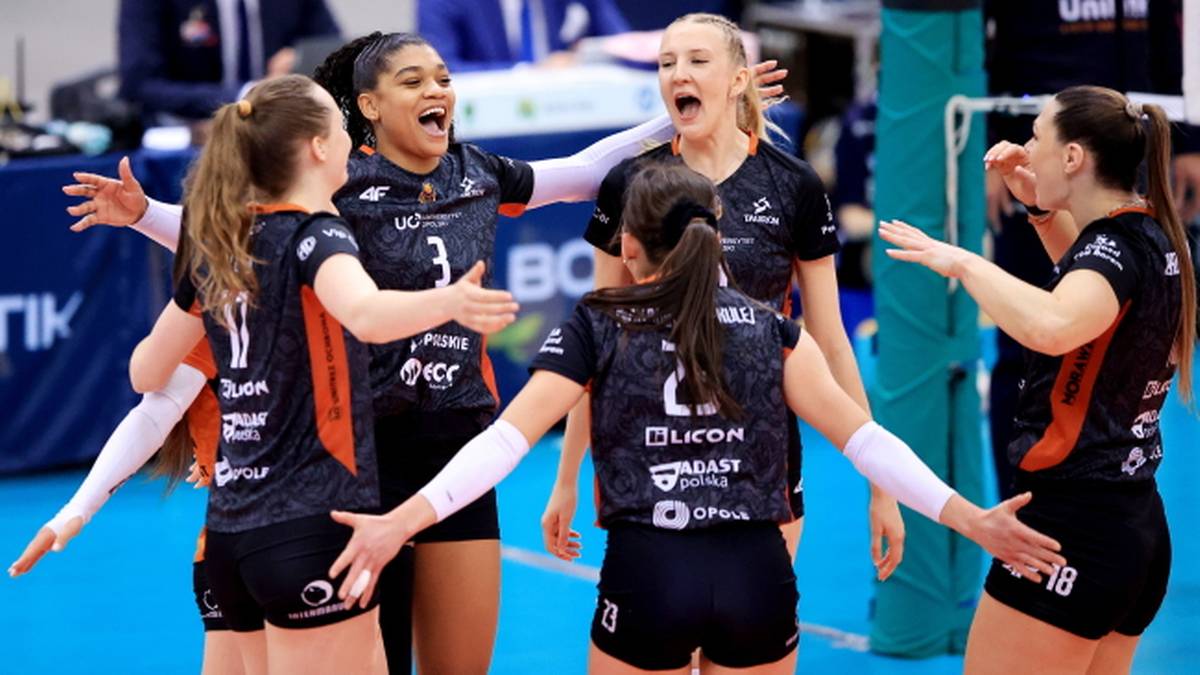 Sześć siatkarek w czarnych strojach świętuje zdobyty punkt, patrząc w stronę sędzi&oacute;w.
