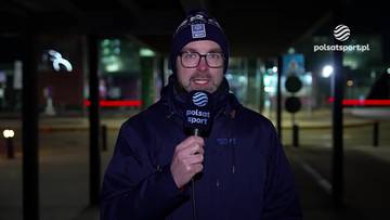 Marcin Lepa z mikrofonem Polsat Sport, ubrany w czapkę i okulary, stoi na zewnątrz o zmierzchu.