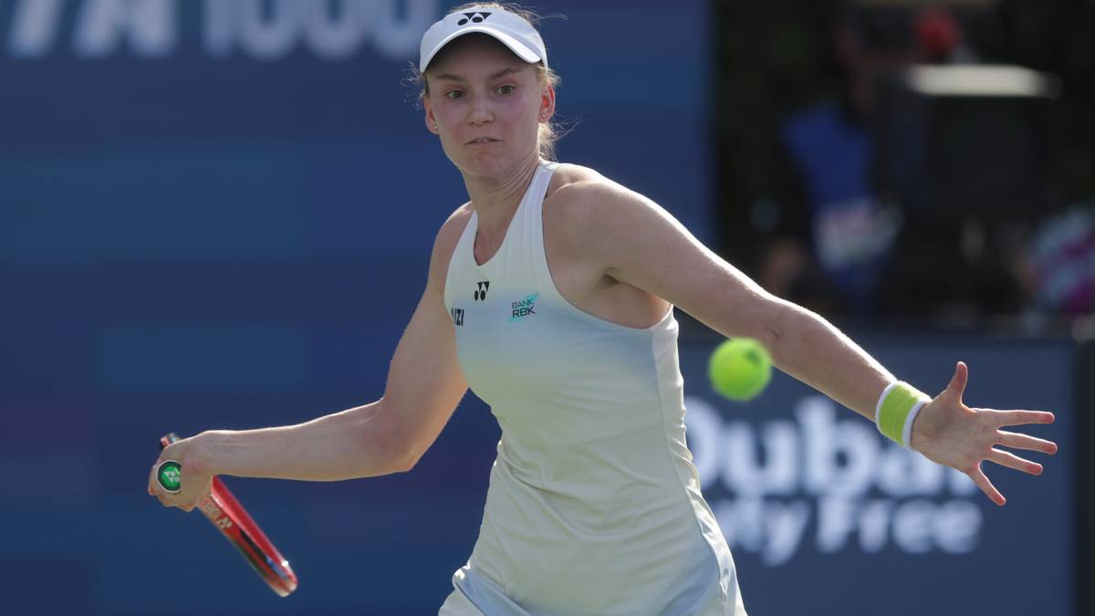 Tenisistka podczas meczu, trzymająca rakietę i przygotowująca się do uderzenia piłki.