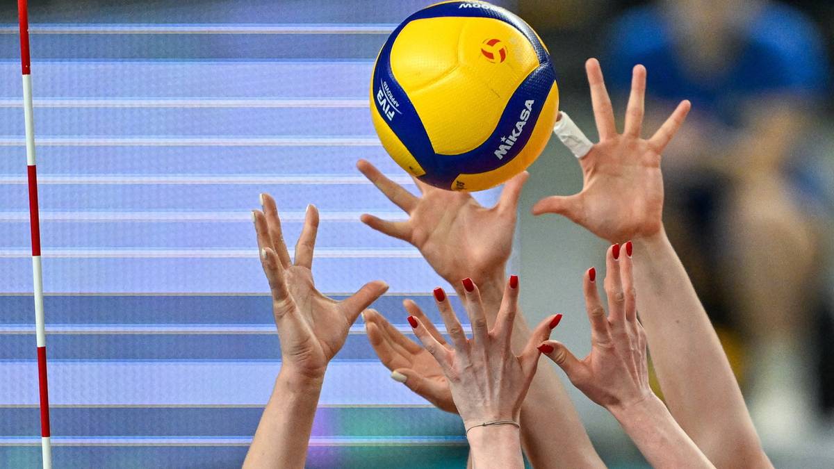 Dłonie siatkarek próbujące odbić piłkę do siatkówki.