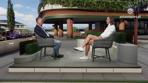 Iga Świątek w białej bluzie i spodniach siedzi w fotelu obok mężczyzny w garniturze, rozmawiając z nim w studiu telewizyjnym.
