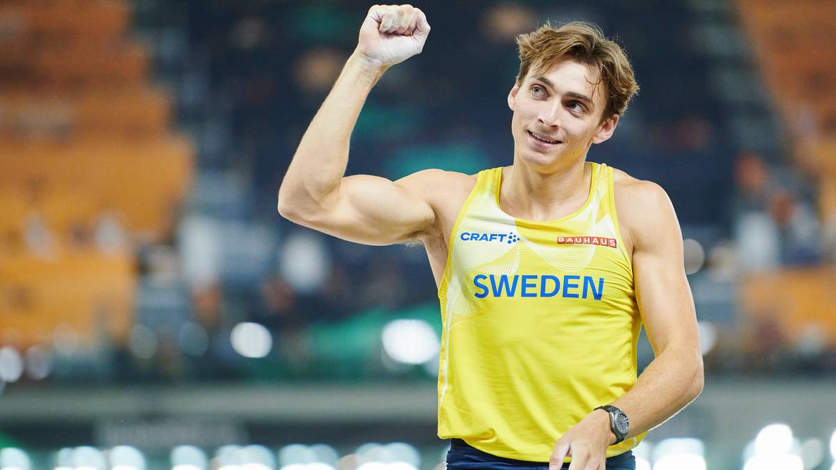 Armand Duplantis, lekkoatleta w ż&oacute;łtej koszulce z napisem "SWEDEN", podnosi prawą rękę w geście radości.