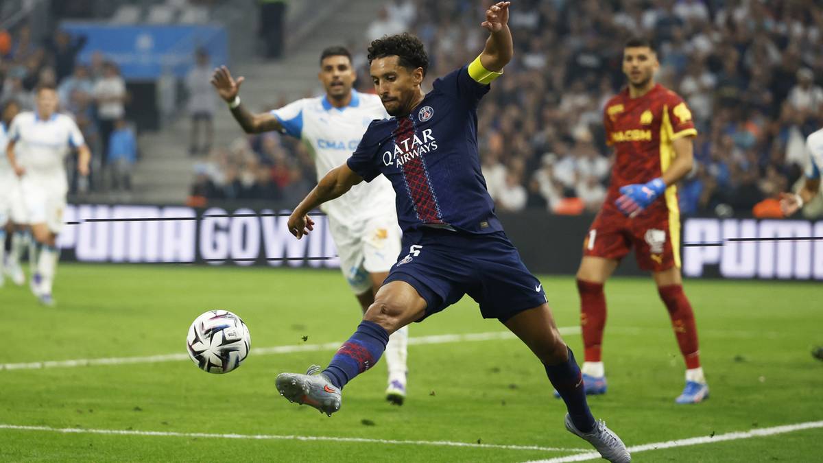 Piłkarz w granatowym stroju PSG z numerem 5 uderza piłkę nogą podczas meczu.