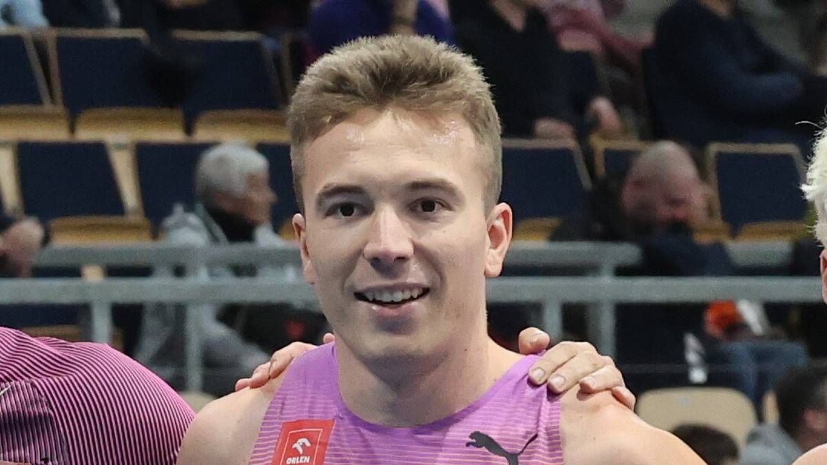 Grupa lekkoatlet&oacute;w pozuje do zdjęcia, stojąc na bieżni.