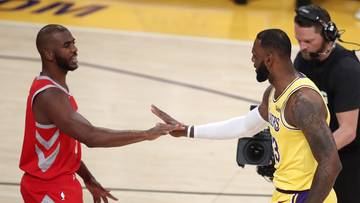 Dw&oacute;ch koszykarzy podaje sobie ręce na boisku podczas meczu.