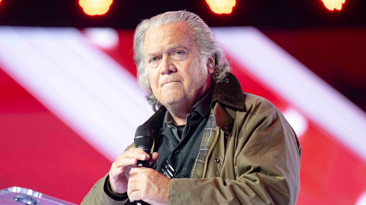 Steve Bannon stoi przy m&oacute;wnicy z mikrofonem.