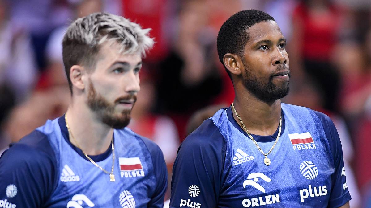 Dw&oacute;ch siatkarzy w niebieskich koszulkach reprezentacji Polski trzyma piłki siatkowe.