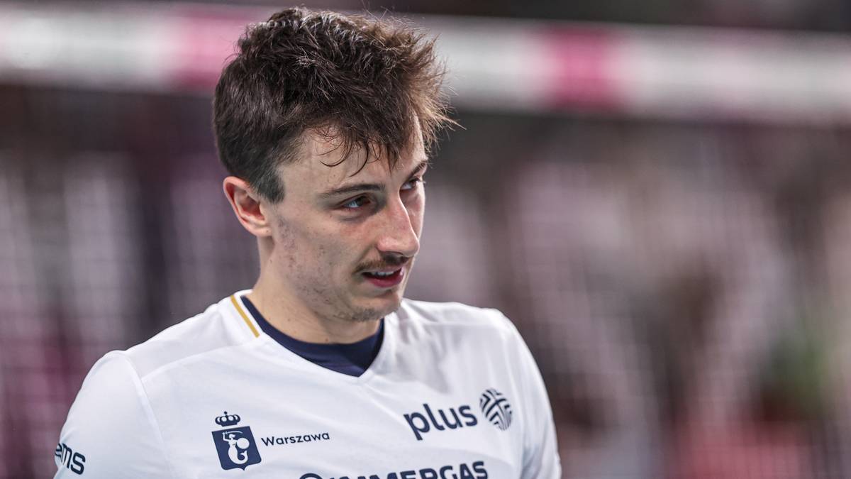 Zbliżenie na twarz siatkarza w białej koszulce z logo drużyny.