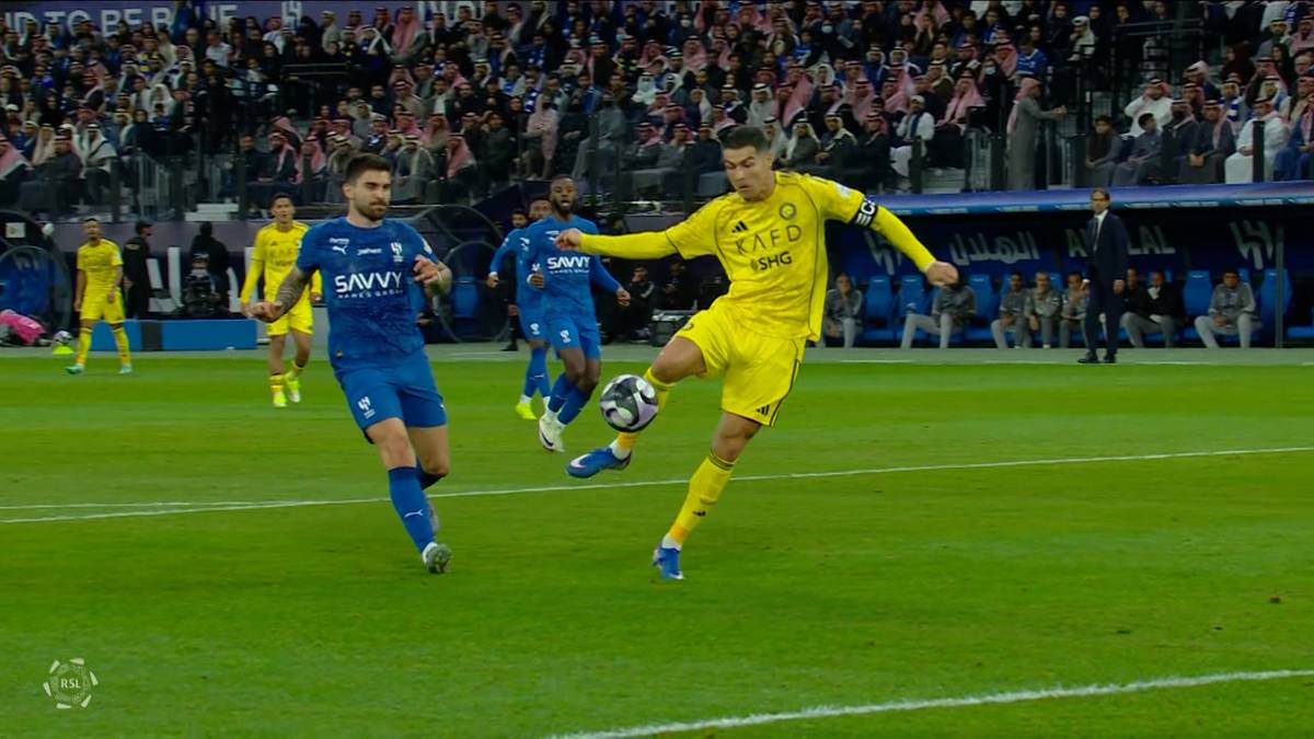 Dw&oacute;ch piłkarzy rywalizuje o piłkę na boisku.