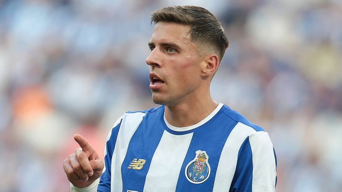 Portret Jana Bednarka, piłkarza FC Porto, w niebiesko-białej koszulce z herbem klubu, podczas meczu na stadionie.