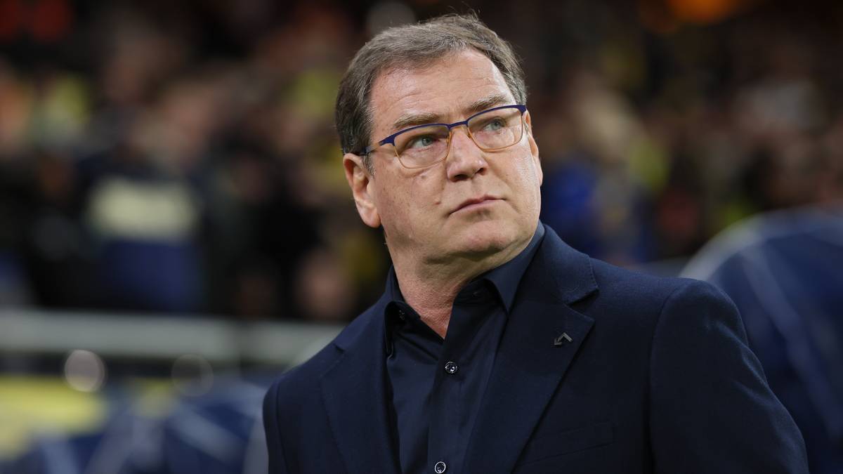 Jan Urban, trener reprezentacji Polski, w okularach i garniturze.