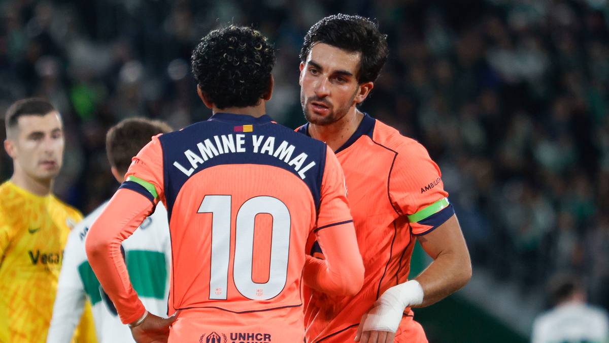 Piłkarze FC Barcelony, Lamine Yamal (numer 10) i Ferran Torres, rozmawiający na boisku.