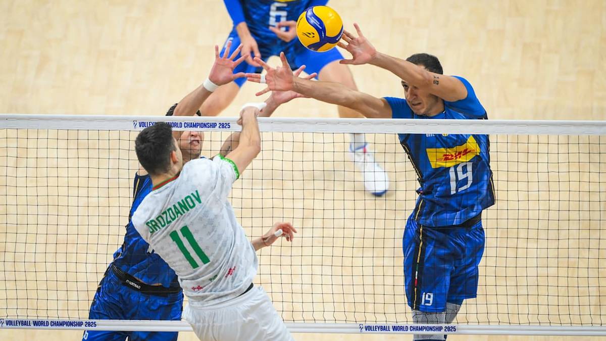 Piłkarze siatkówki rywalizują o piłkę przy siatce podczas meczu.