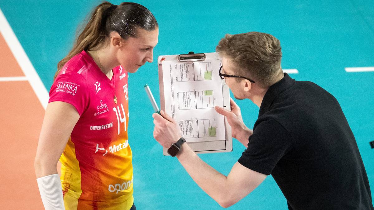 Siatkarka Lotto Chemika Police słucha wskaz&oacute;wek trenera, kt&oacute;ry pokazuje jej notatki na tablicy.