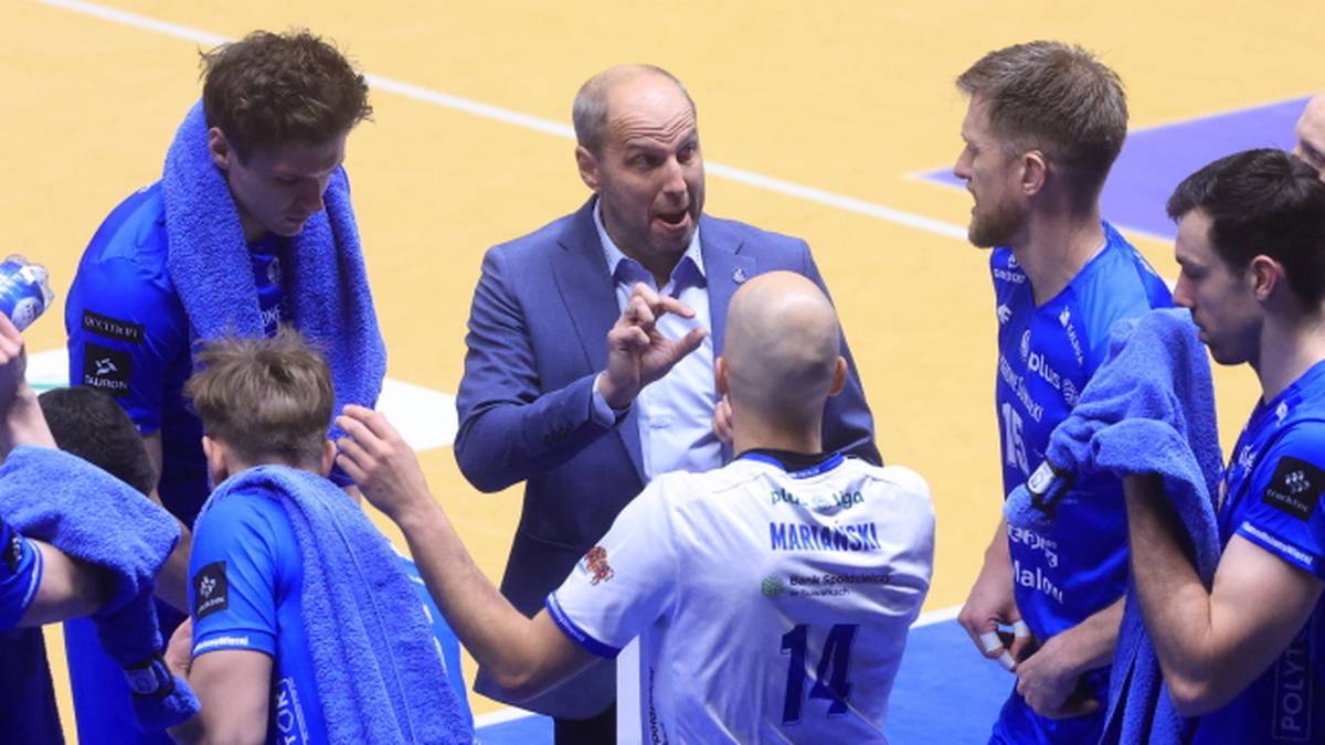 Trener zwraca się do zawodnik&oacute;w podczas przerwy w meczu siatk&oacute;wki.