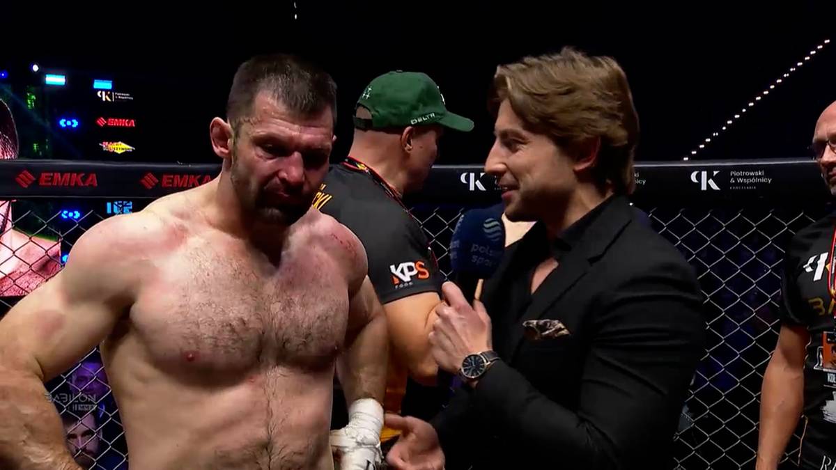 Szymon Kołecki, zawodnik MMA, rozmawia z dziennikarzem po walce, z widocznymi śladami walki.