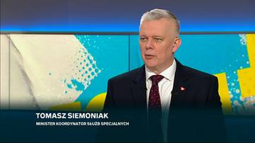 Tomasz Siemoniak, Minister Koordynator Służb Specjalnych, w garniturze i krawacie, przemawia na tle studia telewizyjnego.