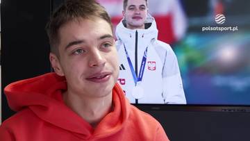 Młody mężczyzna w czerwonej bluzie z kapturem, uśmiechnięty, obok ekranu telewizora z postacią w białej kurtce z polskim godłem i medalem.