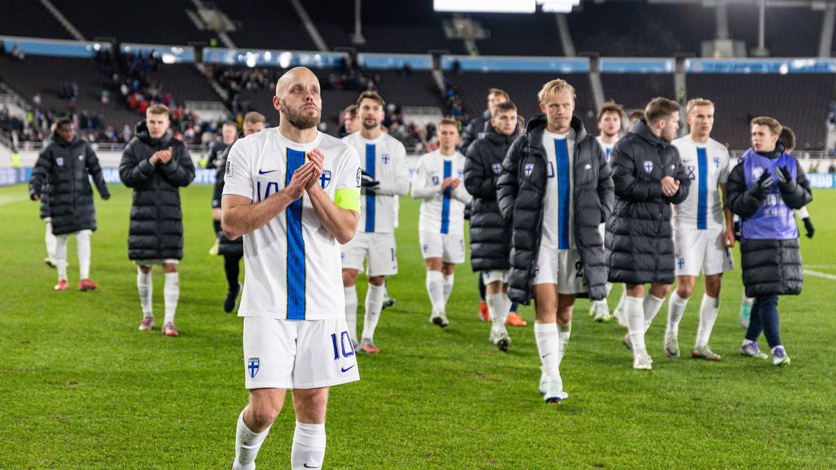 Piłkarze reprezentacji Finlandii na murawie stadionu, niektórzy klaszczą z rozczarowaniem, jeden z zawodników ma złożone ręce na piersi.
