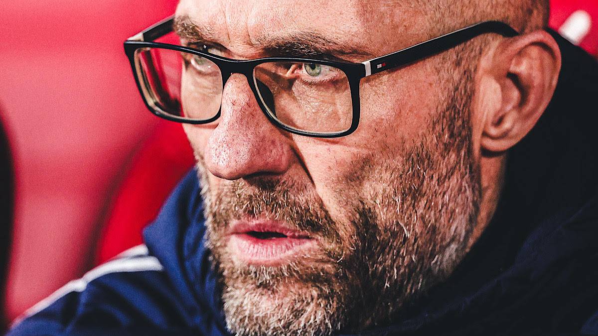 Zbliżenie na twarz trenera piłkarskiego w okularach.