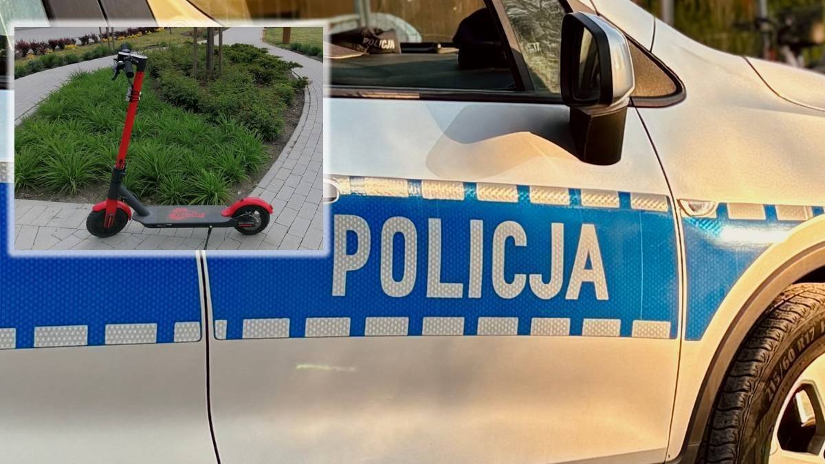 Czerwona hulajnoga elektryczna obok samochodu policyjnego.