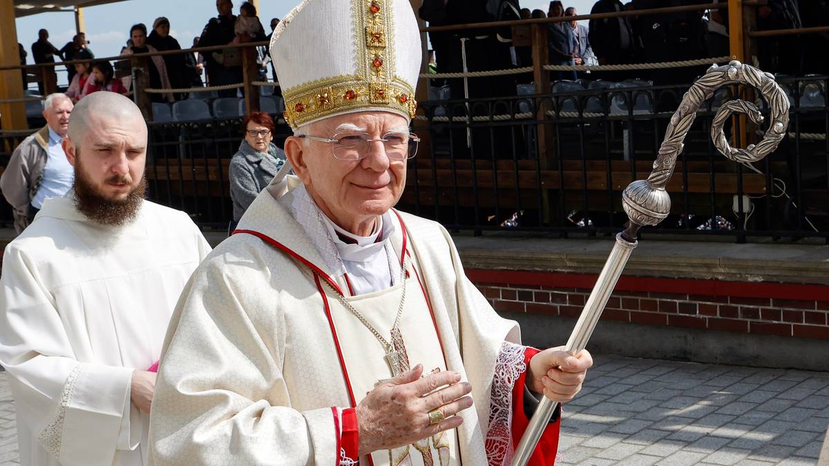 Abp Marek Jędraszewski w białej szacie liturgicznej i mitrze, z pastorałem, na tle zgromadzonych os&oacute;b.