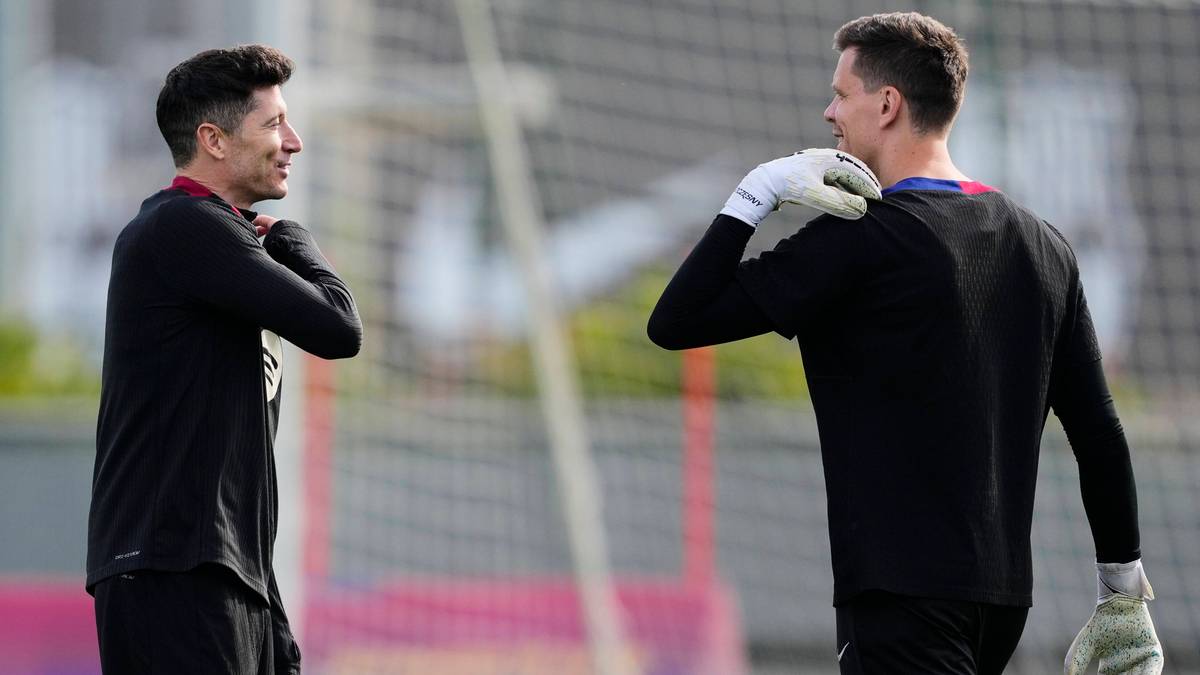 Robert Lewandowski i Wojciech Szczęsny rozmawiają ze sobą na boisku piłkarskim.