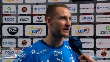 Michał Daszek udziela wywiadu w niebieskim stroju sportowym na tle ścianki sponsorskiej.