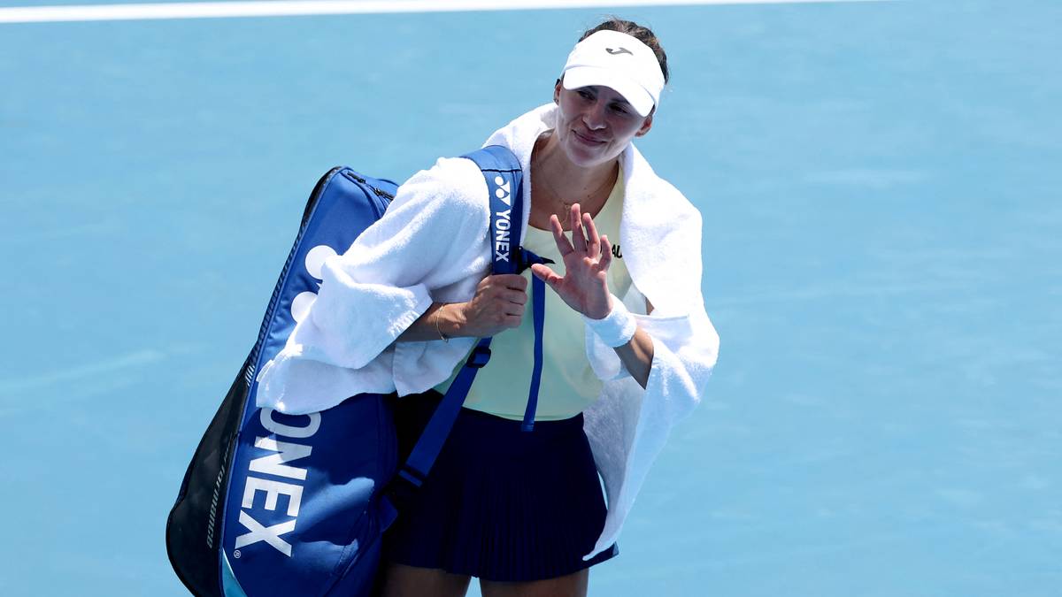 Tenisistka Magda Linette idzie z torbą na ramieniu po korcie.