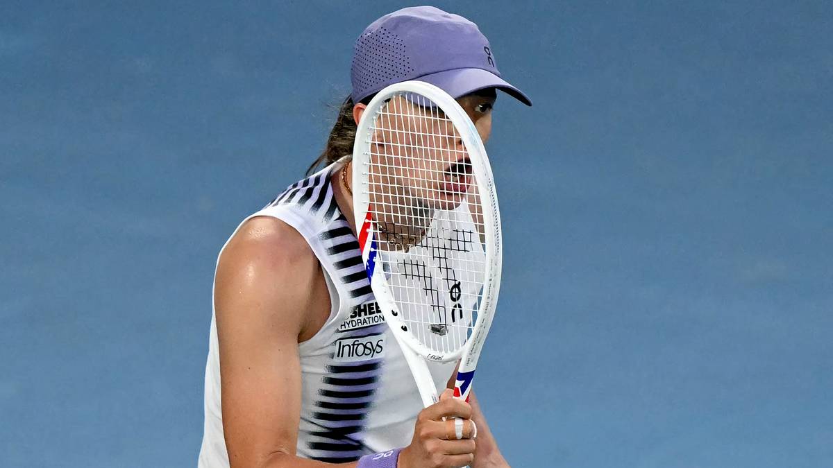 Iga Świątek podczas meczu tenisowego, trzyma rakietę i jest w trakcie uderzenia.