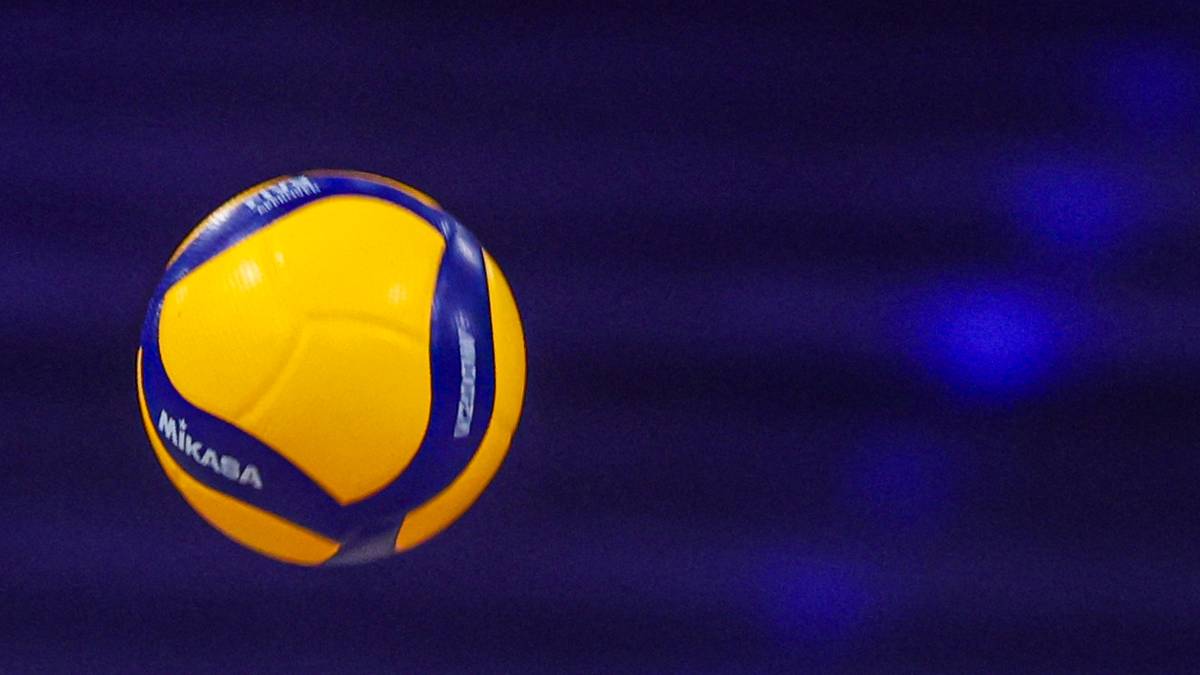 Ż&oacute;łta piłka do siatk&oacute;wki z niebieskimi pasami i logo Mikasa na ciemnoniebieskim tle.