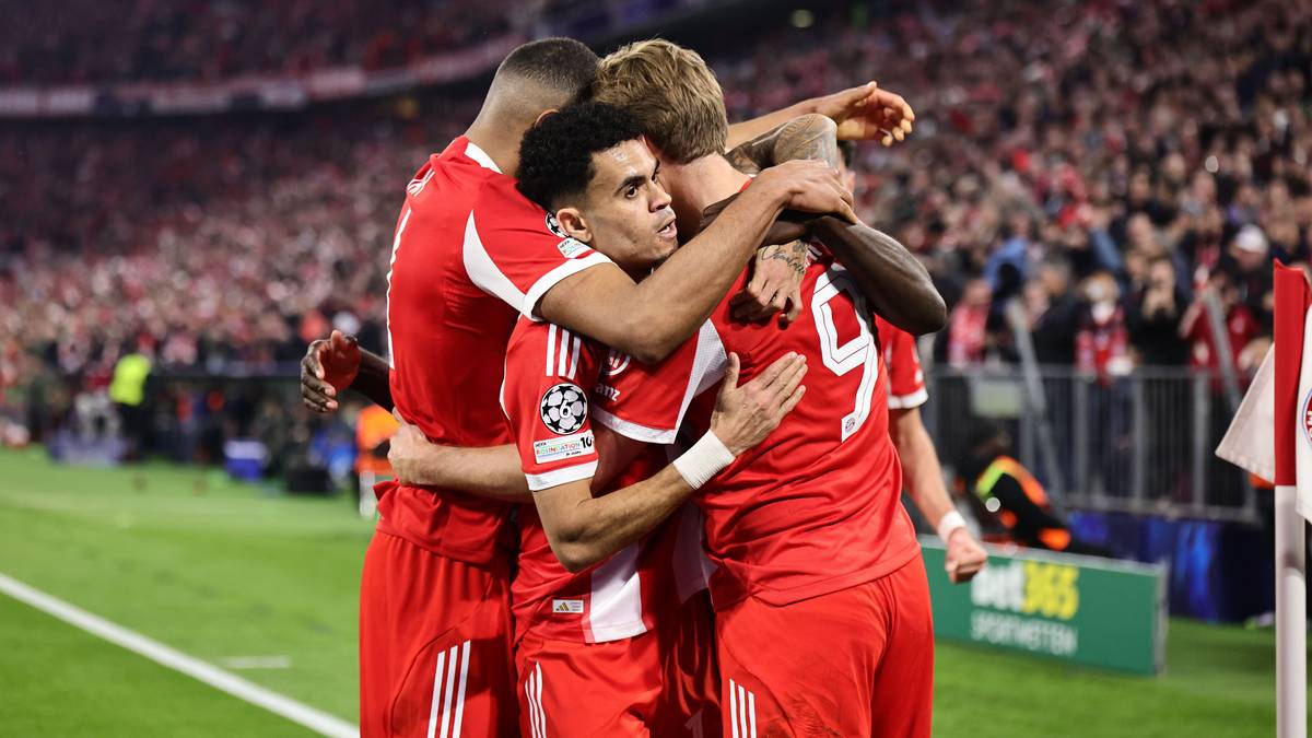 Piłkarze Bayernu Monachium świętują zdobycie bramki, przytulając się na boisku.