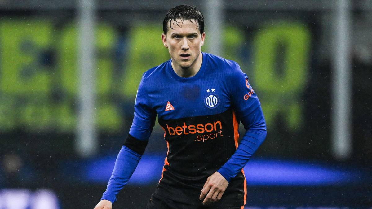 Piłkarz Interu Mediolan w niebiesko-czarnym stroju na boisku z piłką przy nodze.