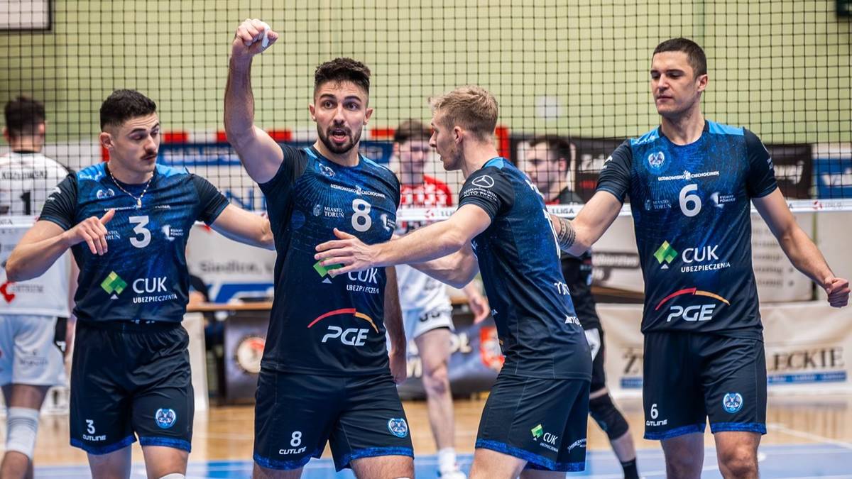 Siatkarze w strojach klubowych świętują zwycięstwo, unosząc ręce i przybijając sobie piątki.