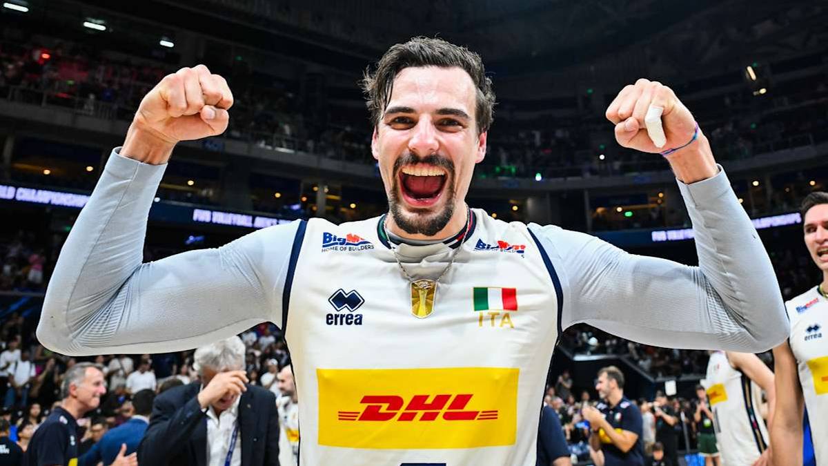 Simone Giannelli napina bicepsy z radością, ubrany w bluzę sportową z logo DHL.