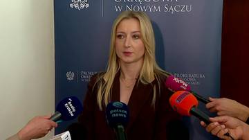 Kobieta przed tłem Prokuratury Okręgowej w Nowym Sączu przemawia do mikrofon&oacute;w dziennikarzy.