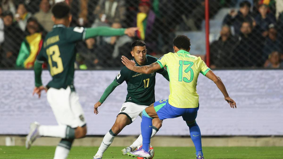 Trzech piłkarzy na boisku, trzech zawodnik&oacute;w walczy o piłkę podczas meczu piłki nożnej.