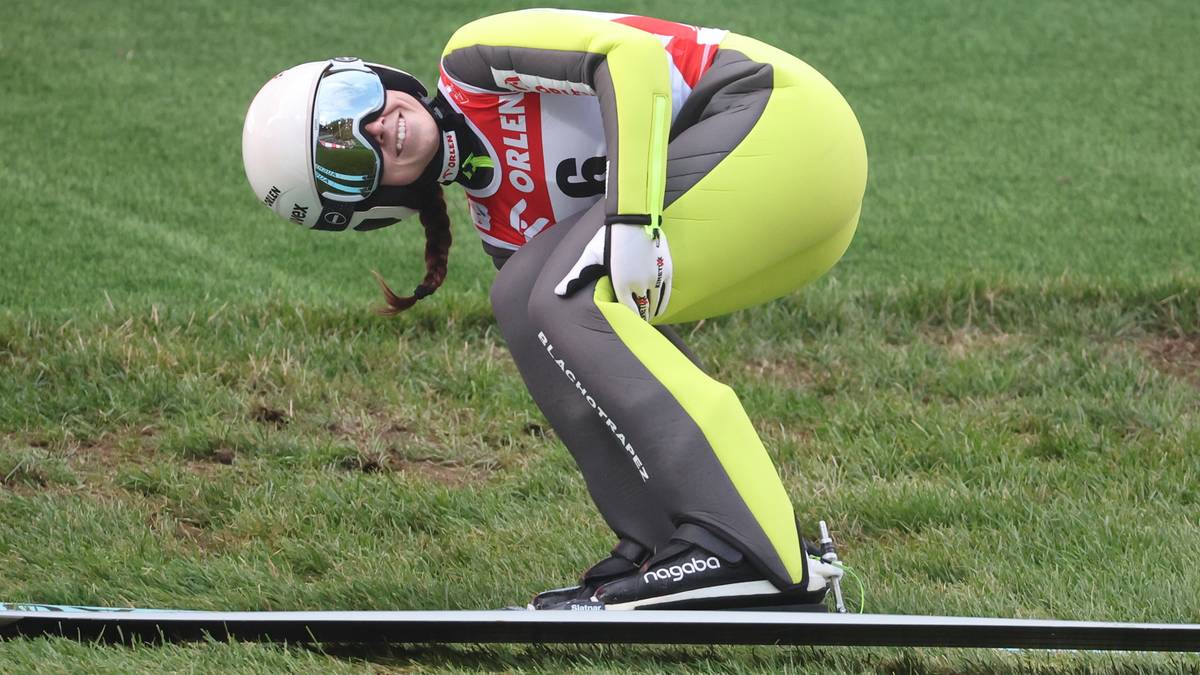 Zawodniczka w stroju narciarskim podczas skoku.