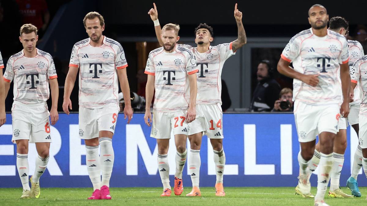 Piłkarze w białych strojach z logo T-Mobile świętują na boisku piłkarskim.