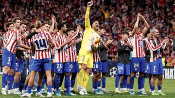 Piłkarze Atletico Madryt świętują zwycięstwo na boisku, wielu z nich unosi ręce w geście radości.