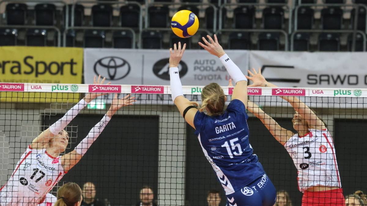 Siatkarki blokują atak podczas meczu siatkówki.