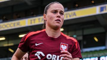 Piłkarka w czerwonej koszulce reprezentacji Polski z białymi getrami biegnie po murawie stadionu.